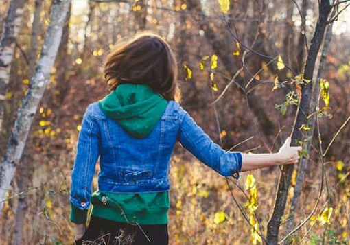 Girl with arm gripping tree