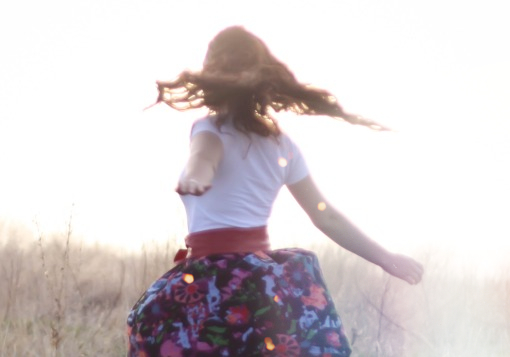 Girl spinning in field | Girl Defined