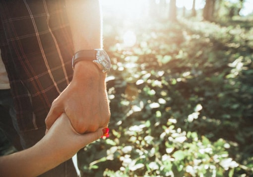 Girl holding guy's hand.