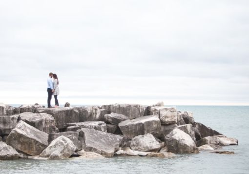 Guy girl on rocks by beach