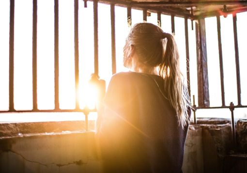 girl looking out bars